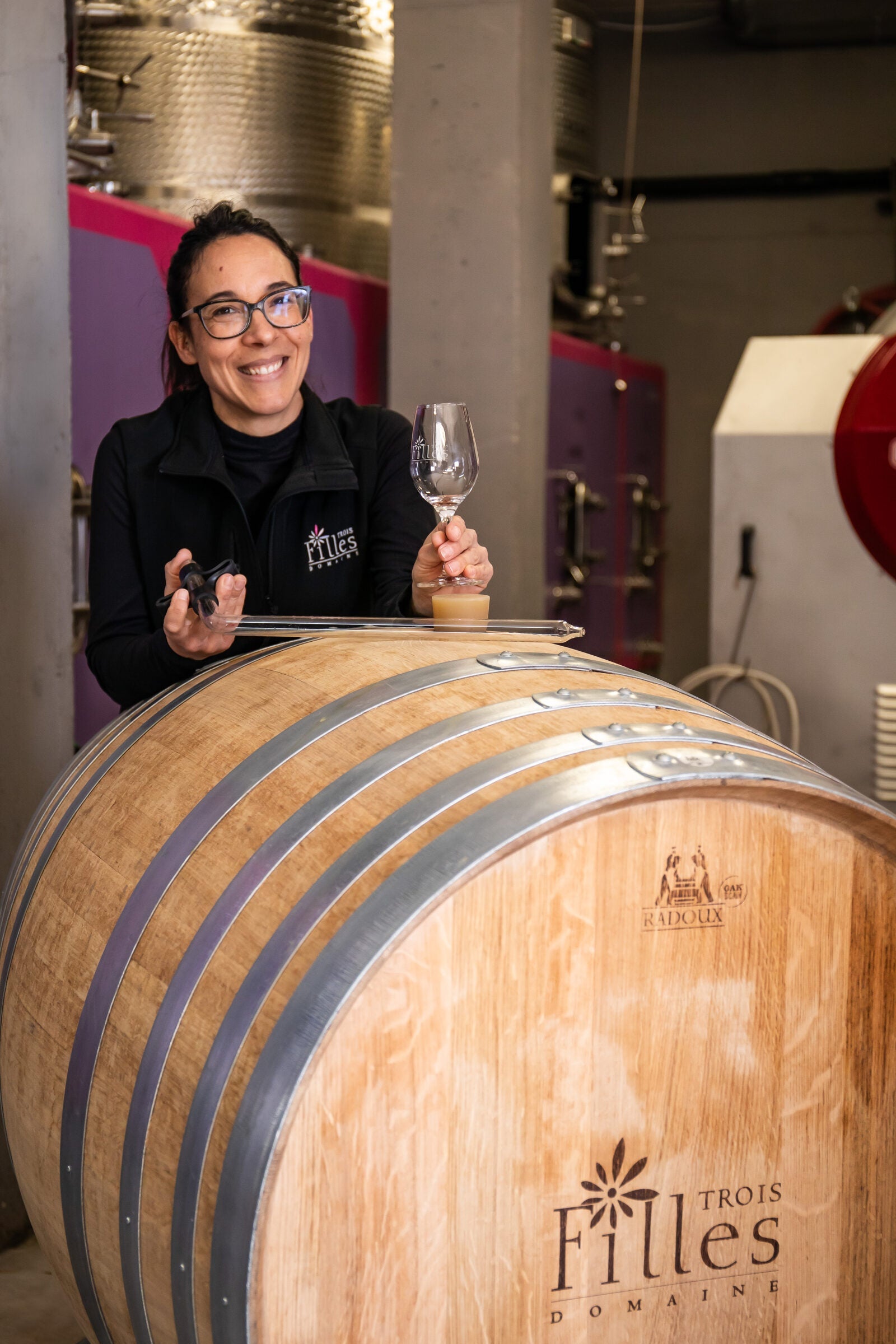 Audrey Arlon mit einem Glas Rosé am Fass der Domaine des Trois Filles