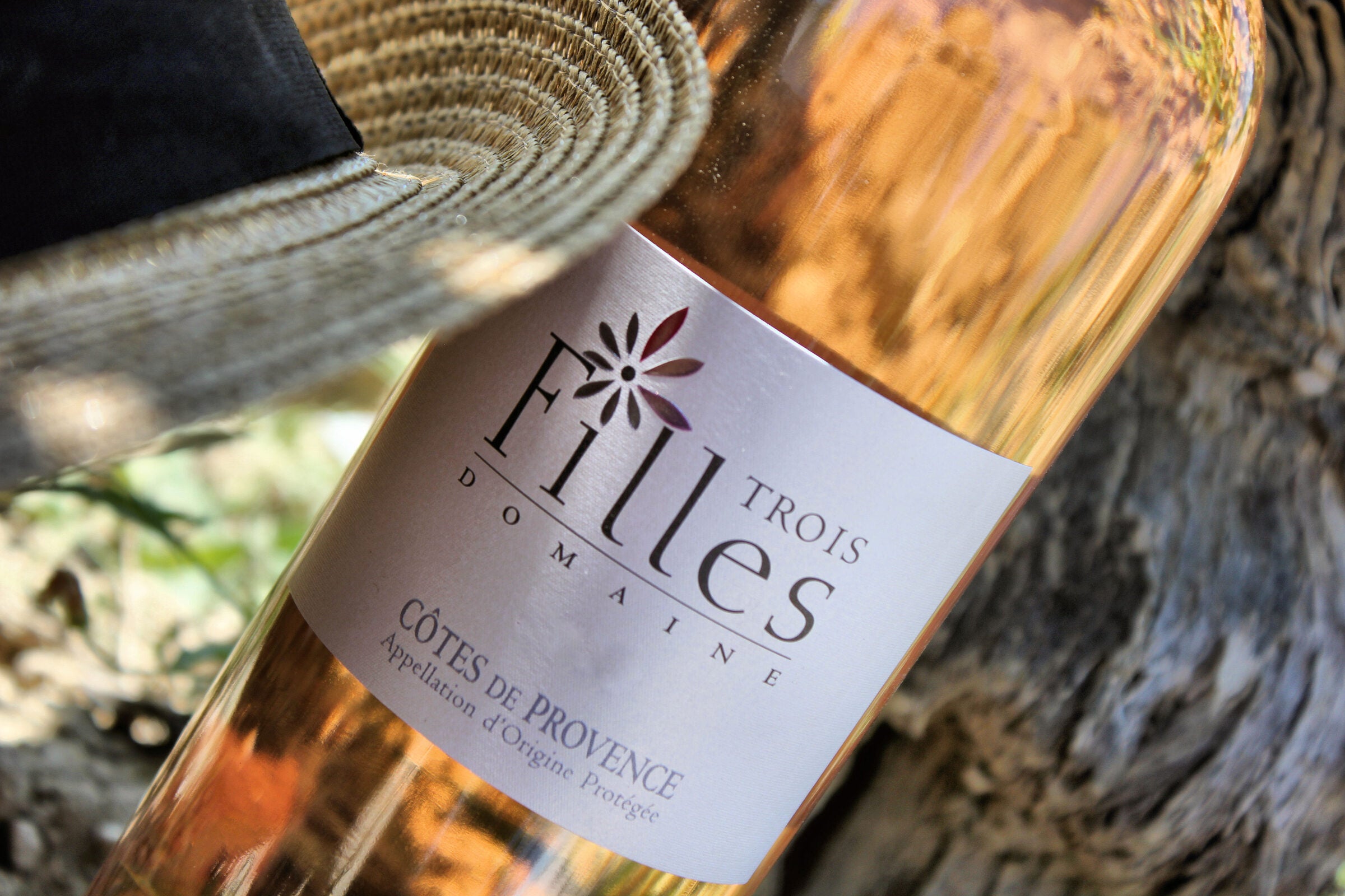 Eine Flasche Trois Filles Rosé im Weinberg der Domaine