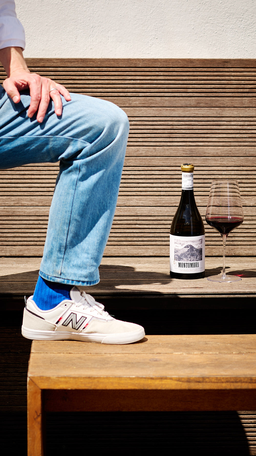 Stehende Person mit einem Glas Rotwein